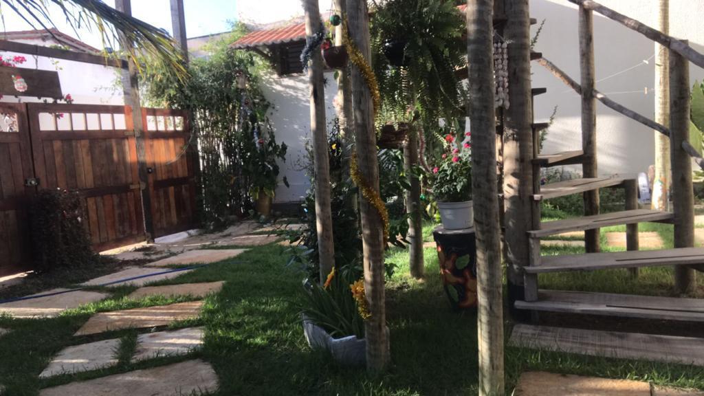 Entrada a la villa con valla de madera natural y palmeras verdes