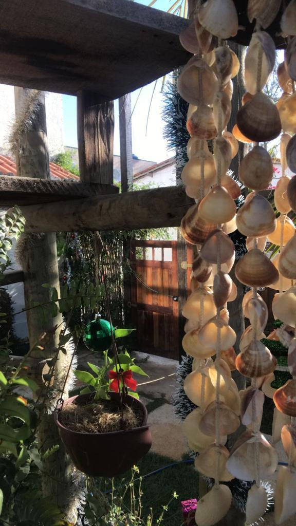 Exterior de la villa con muros claros y cercado de madera rústica